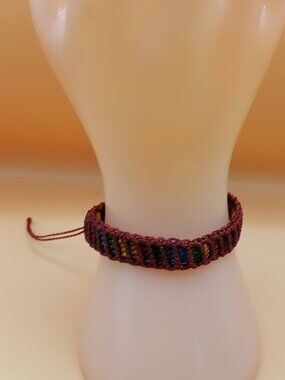 Hand-woven macrame bracelet with multicolored thread and adjustable closure.